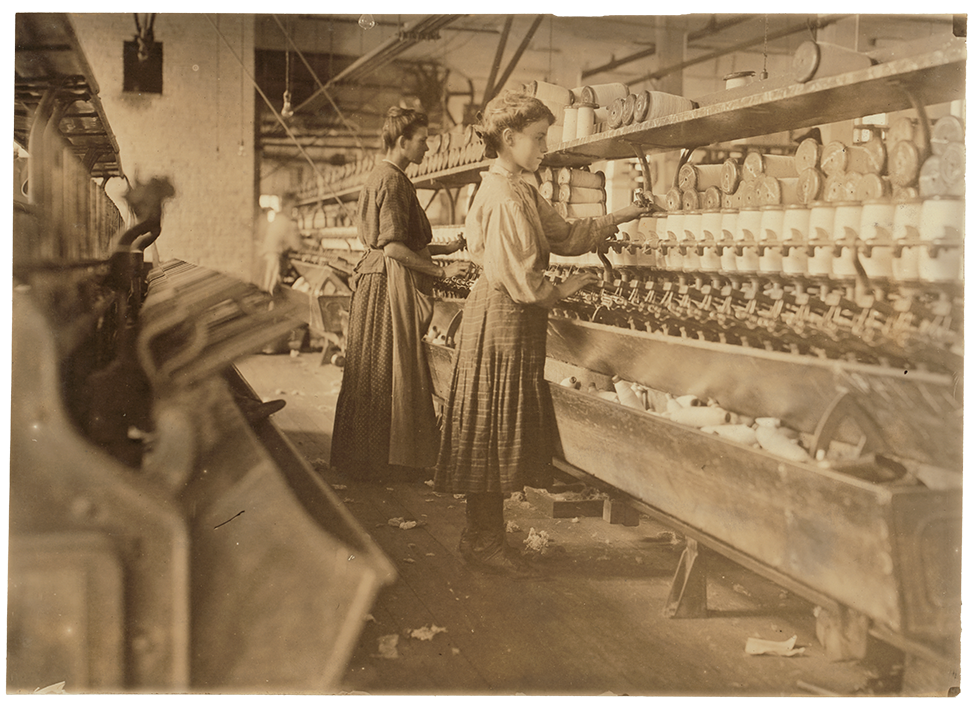 Photograph of mother and daughter standing and working in front of machines in a mill.