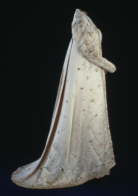 Dolly Madison’s French empire-style, long-sleeved, white silk satin, short train, open robe with embroidered red and pink flowers along the border and down the sleeves, as well as butterflies, dragonflies, and phoenixes on the back and sides.
