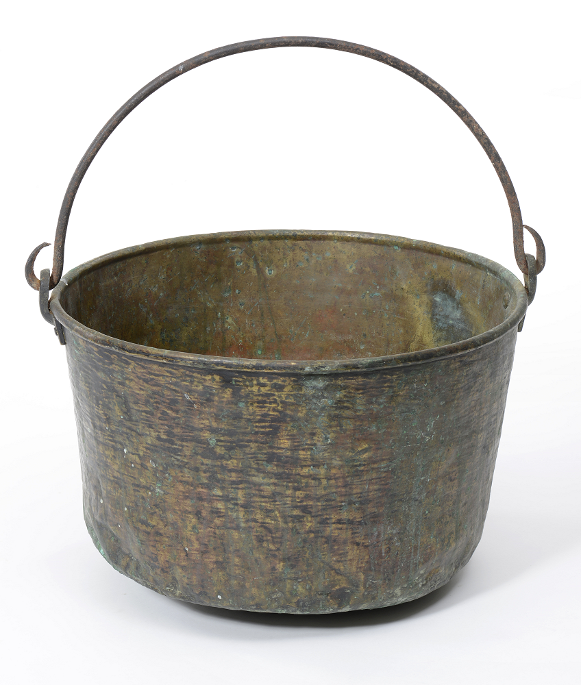 Large, rustic brass kettle with a handle, minor verdigris tarnish, and a reinforced lip over a wrought iron ring. Dimensions: 12” tall X 17” diameter.
