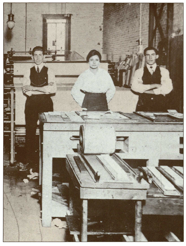 An image of Jovita Idar from a postcard, pictured at a printing press with two young men beside her. 